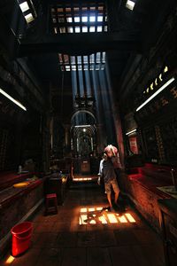 Rear view of woman walking in tunnel