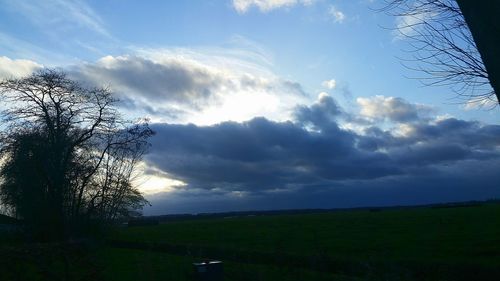 Scenic view of field against cloudy sky