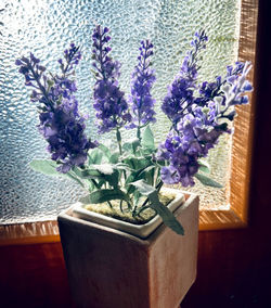 Purple flowering plants in vase on table