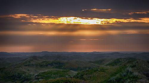 Scenic view of mountains against sky at sunset