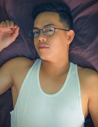 Portrait of handsome young man lying on bed at home