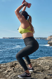 Full length of woman standing at beach against sky