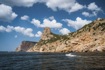 Scenic view of sea and mountains against sky