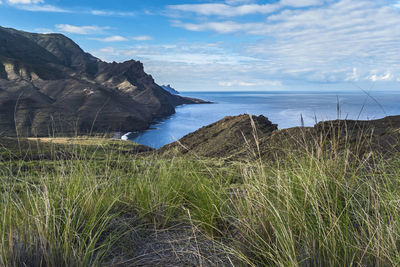 Scenic view of sea and mountains against sky