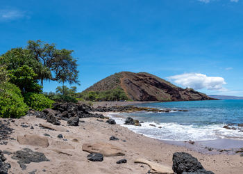 Scenic view of beach against blue sky