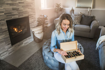 Young woman sitting on sofa at home