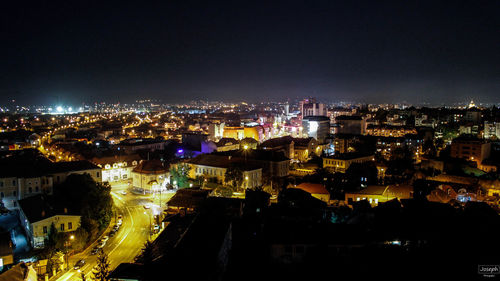 Illuminated cityscape against sky at night