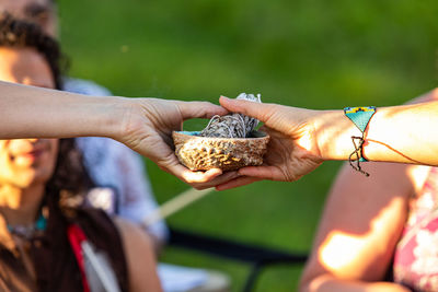 Cropped hands holding bowl and papers