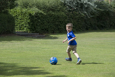Boy playing soccer on grassy field