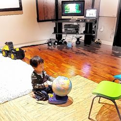 Full length of young woman photographing while standing against wall