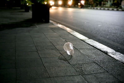 High angle view of plastic cup on footpath