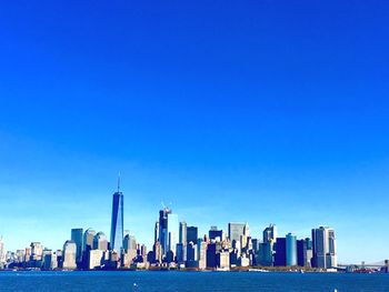 Modern buildings in city against blue sky