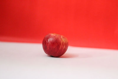 Close-up of strawberry on table against red background