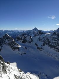 Scenic view of snow mountains against blue sky