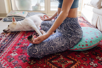 Dog sleeping on the carpet while her owner meditating and burning sage