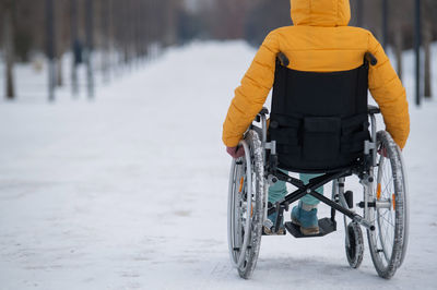 Rear view of man walking on snow