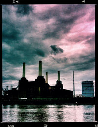 Buildings in city against cloudy sky