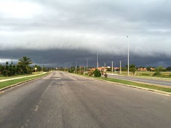 Empty road against cloudy sky