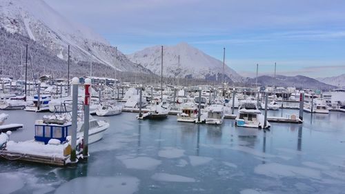 Sailboats moored on snowcapped mountains against sky