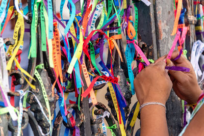 Tourist hands tying souvenir ribbons on the railing of the senhor do bonfim church 