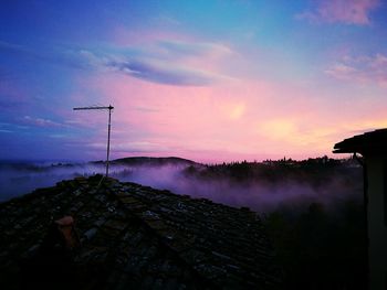 Low angle view of silhouette crane against sky during sunset