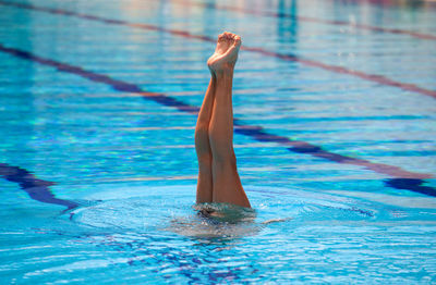 Low section of woman swimming in pool