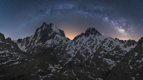 Scenic view of snowcapped mountains against sky at night