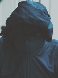 Close-up portrait of man covering face with jacket