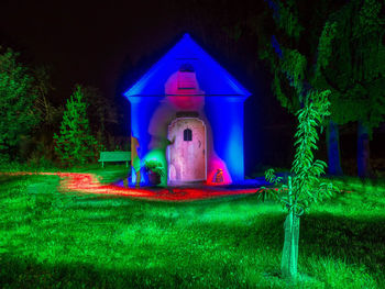 Illuminated sculpture by building at night