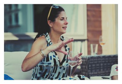 Woman looking away while sitting on table