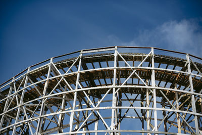 Low angle view of ferris wheel against blue sky