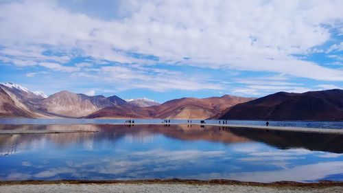 Scenic view of lake by mountains against sky