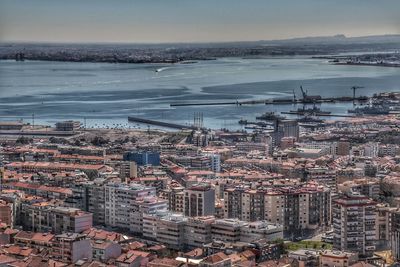 High angle view of cityscape by sea against sky