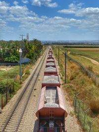 View of railroad tracks on field against sky