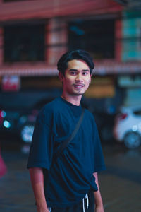 Young man standing on street in city