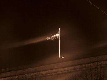 Low angle view of illuminated lights against sky at night