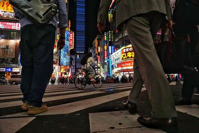 Low section of people walking on city street