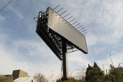 Low angle view of a billboard against sky