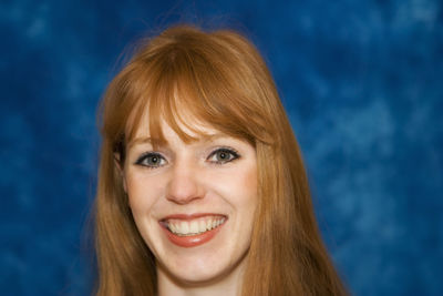 Close-up of beautiful woman against blue wall