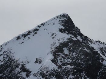 Low angle view of snowcapped mountain against clear sky