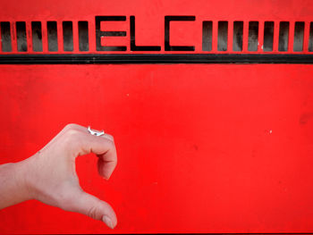 Close-up of hand holding red wall