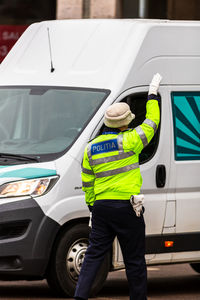 Rear view of man working in car