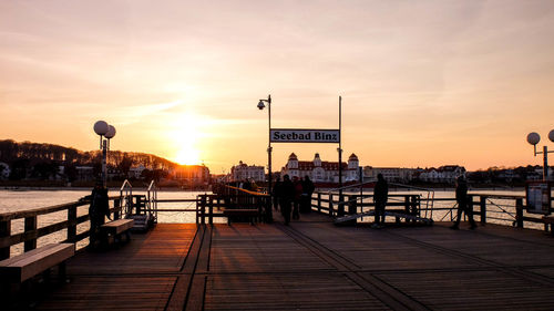 Pier on sea against sky during sunset
