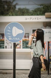 Portrait of young woman standing in city
