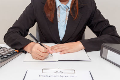 Midsection of woman with umbrella on table