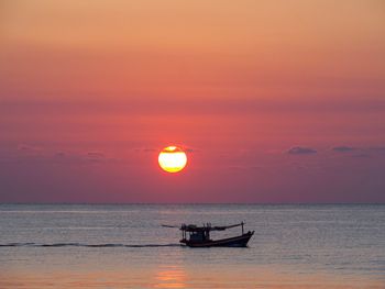 Boat in sea against sky during sunset