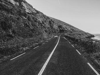 Road by mountain against clear sky