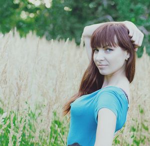 Portrait of young woman standing by plants