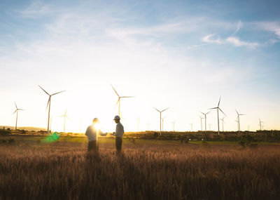 Windmills on field against sky