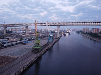 Bridge over river in city against sky
